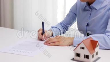 有房子模型和<strong>签字笔</strong>的女人
